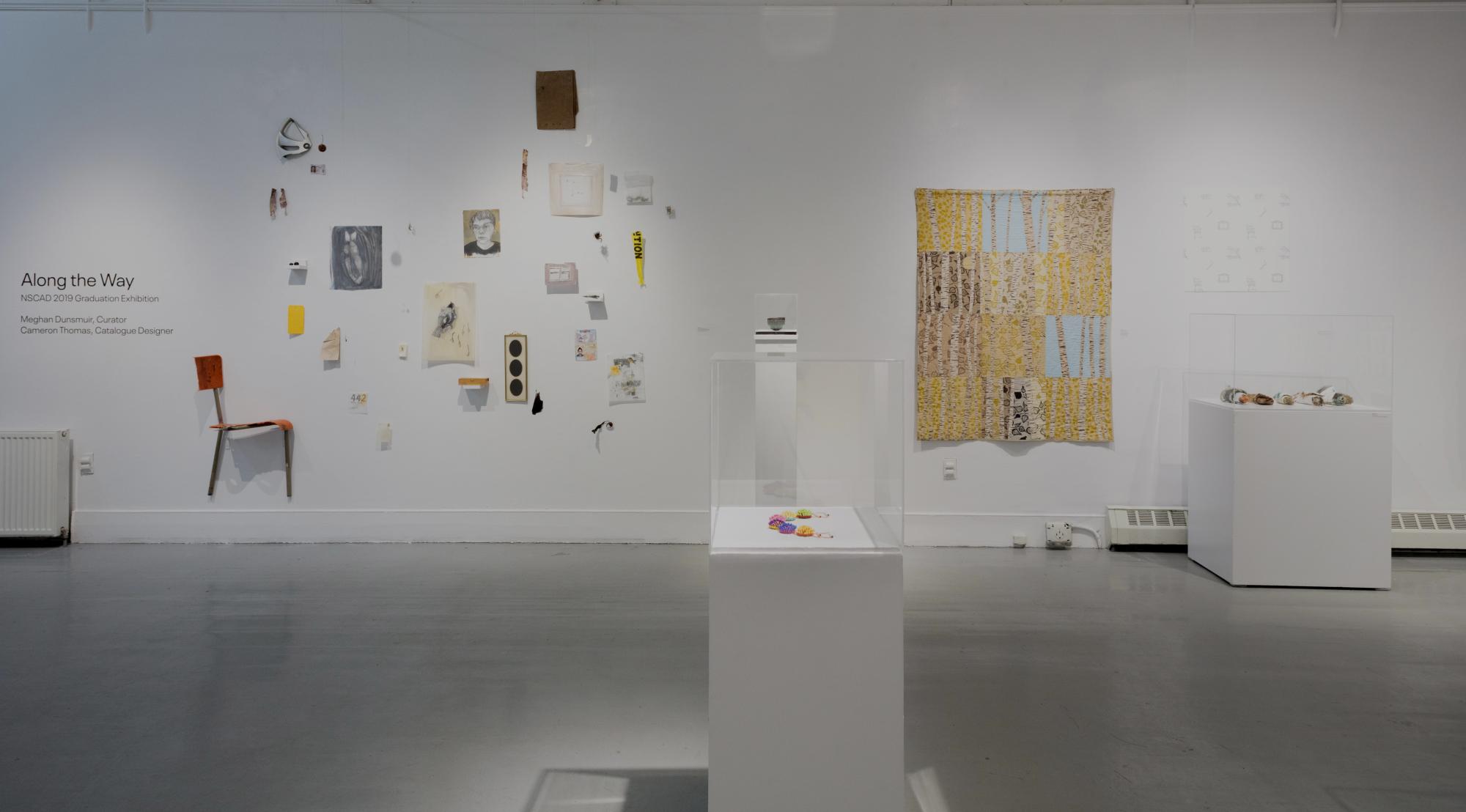 2019 Graduation exhibition installation. Small drawings and found objects are on the wall next to a textile hanging.