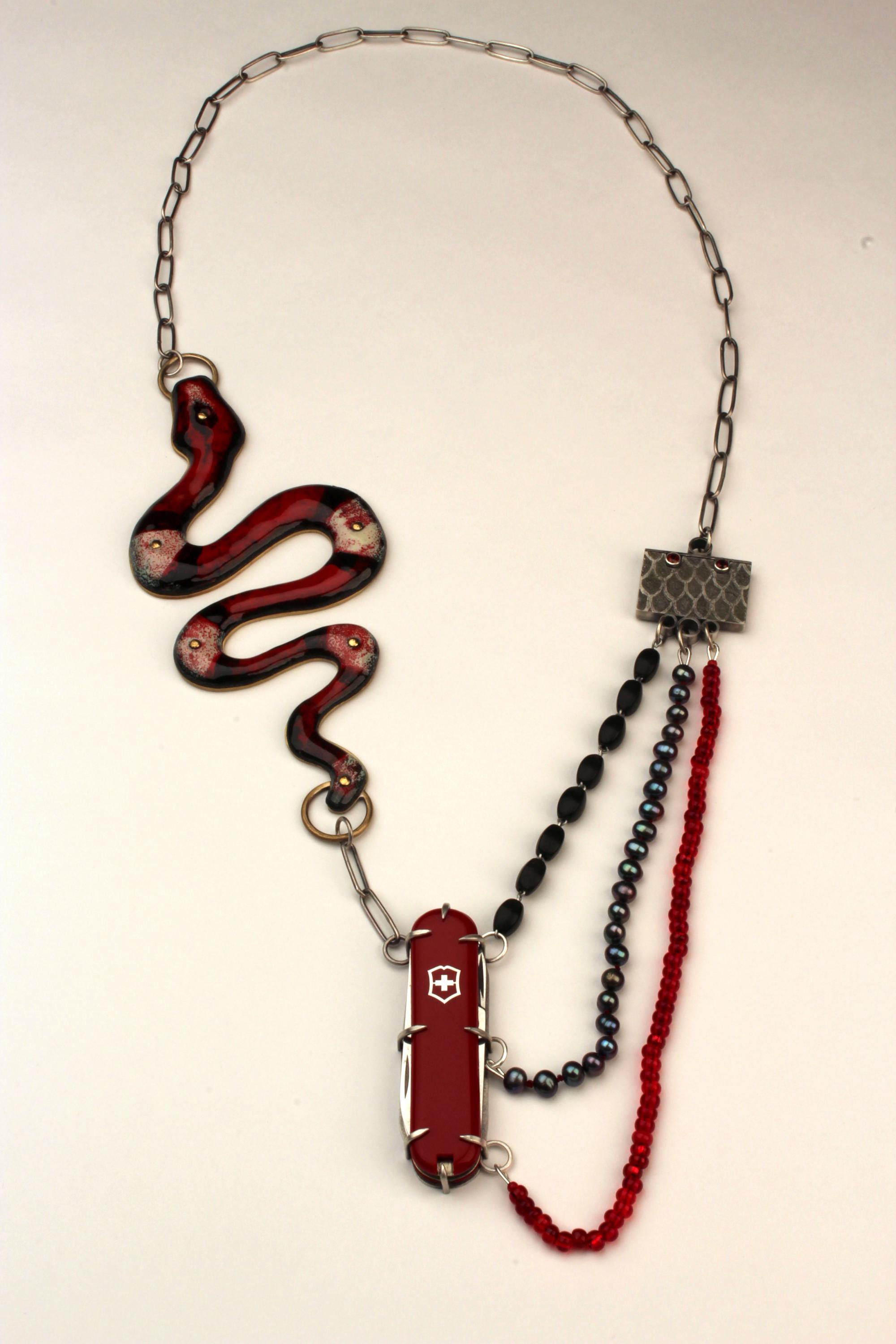 a necklace made with an snake, chain, swiss army knife and beads