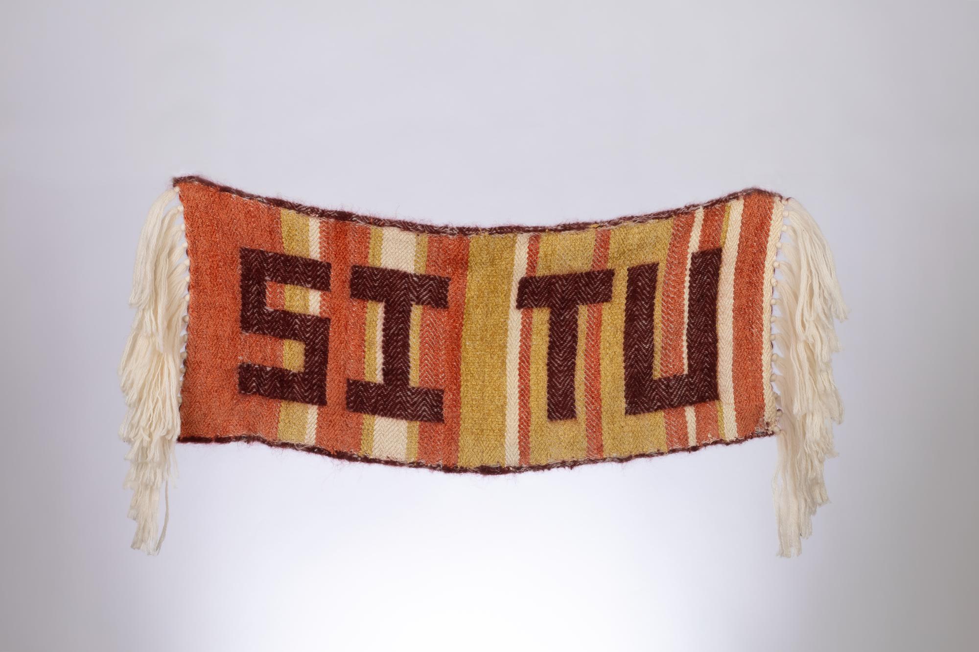 Orange, yellow and beige weaving with the letters "SI TU" in burgundy 