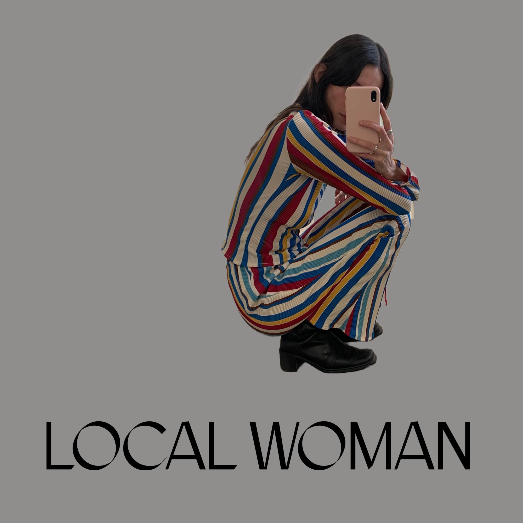 Medium dark grey background, with model collaged onto background. Model is light skinned with long and dark brown hair, crouching in brightly coloured and striped outfit, with phone in front of face to take photo. Black text at bottom reads ‘LOCAL WOMAN