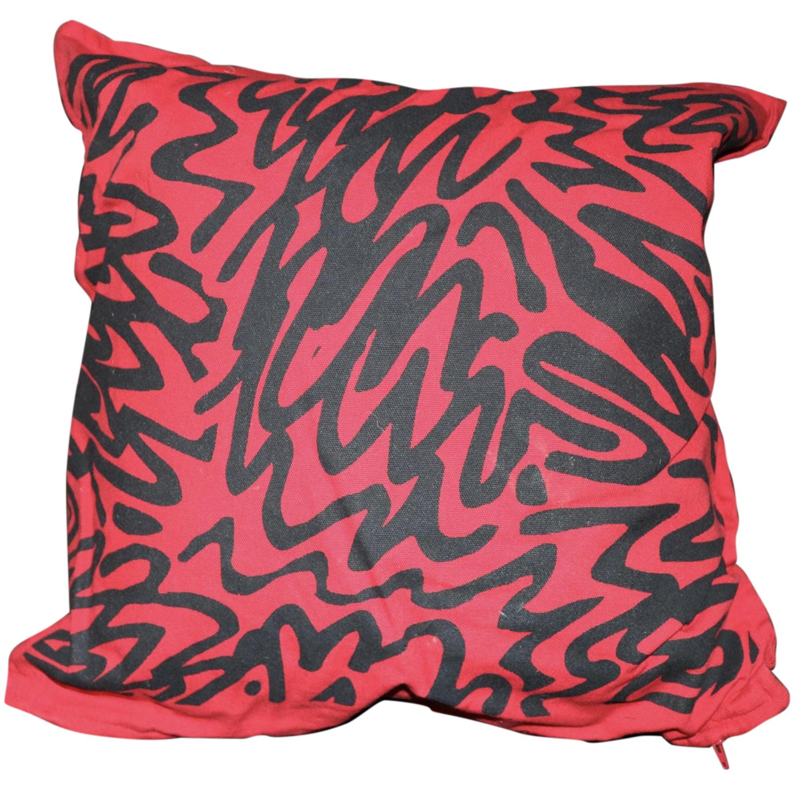Hand-screen printed on cotton, the pillow design boasts a bold, simple pattern on a red background.