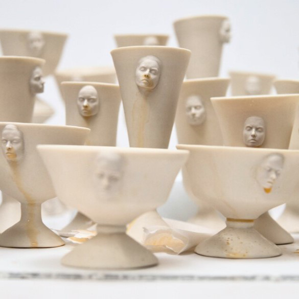 White open topped vessels with faces protruding