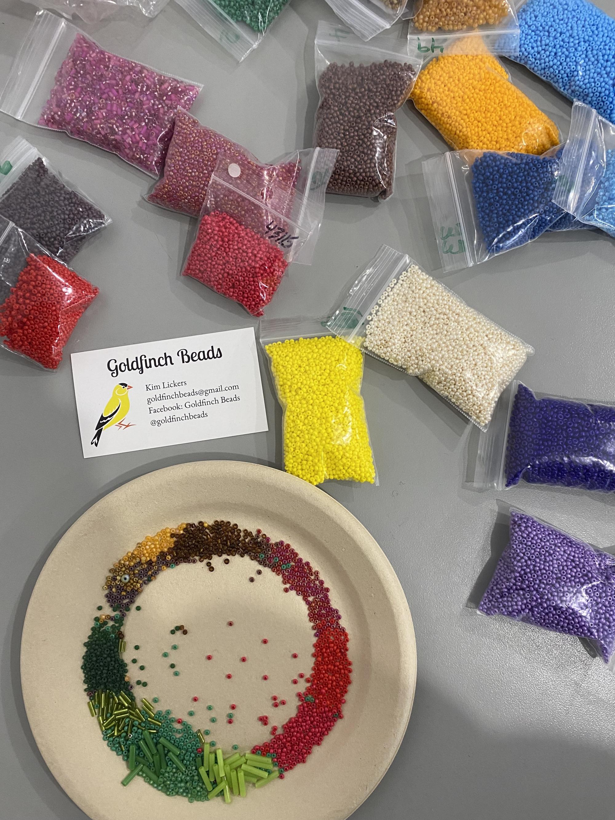 glass seed beads in baggies and many colours spread out on the table