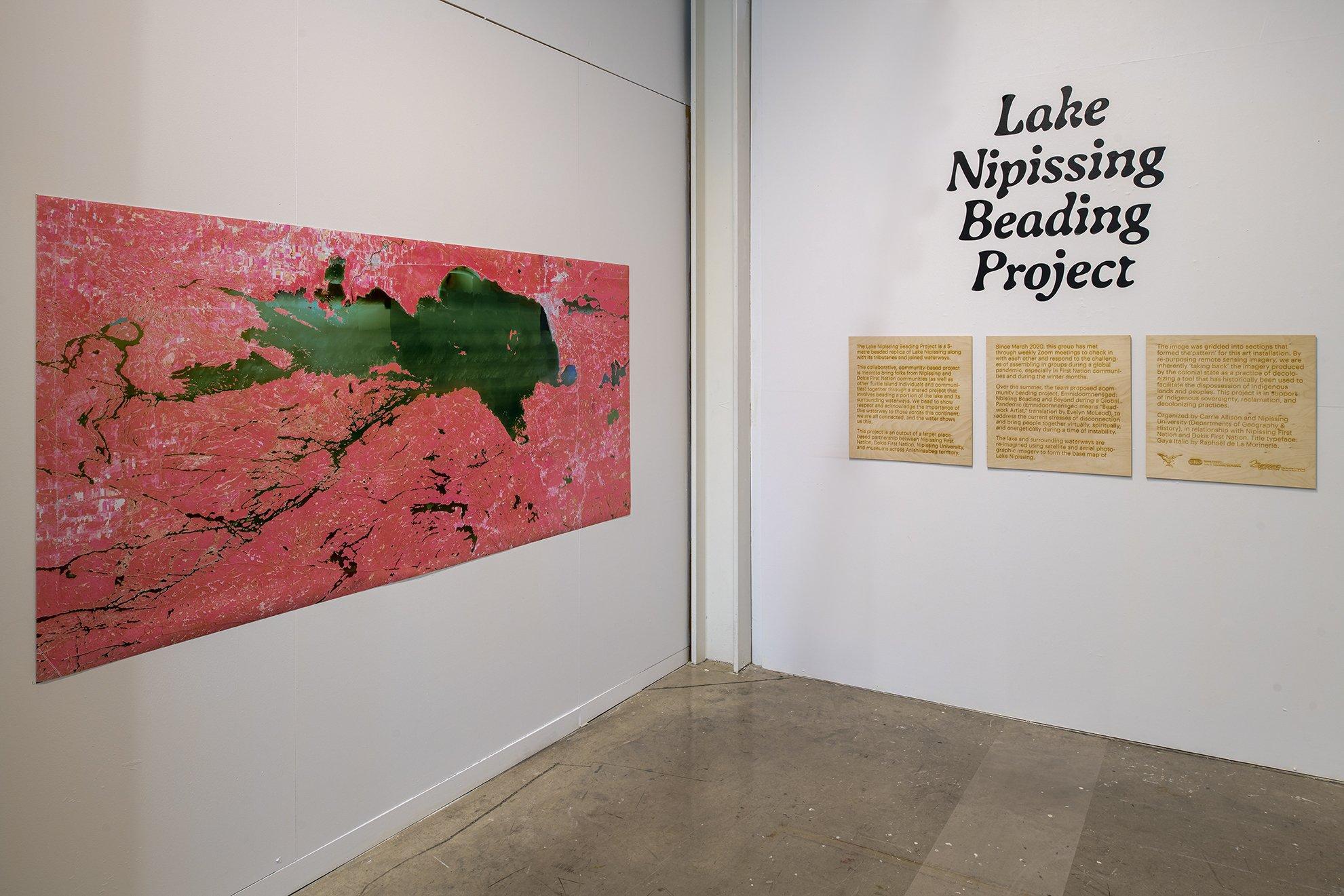 pink and green gis map of Lake Nipissing and exhibition text printed on wood