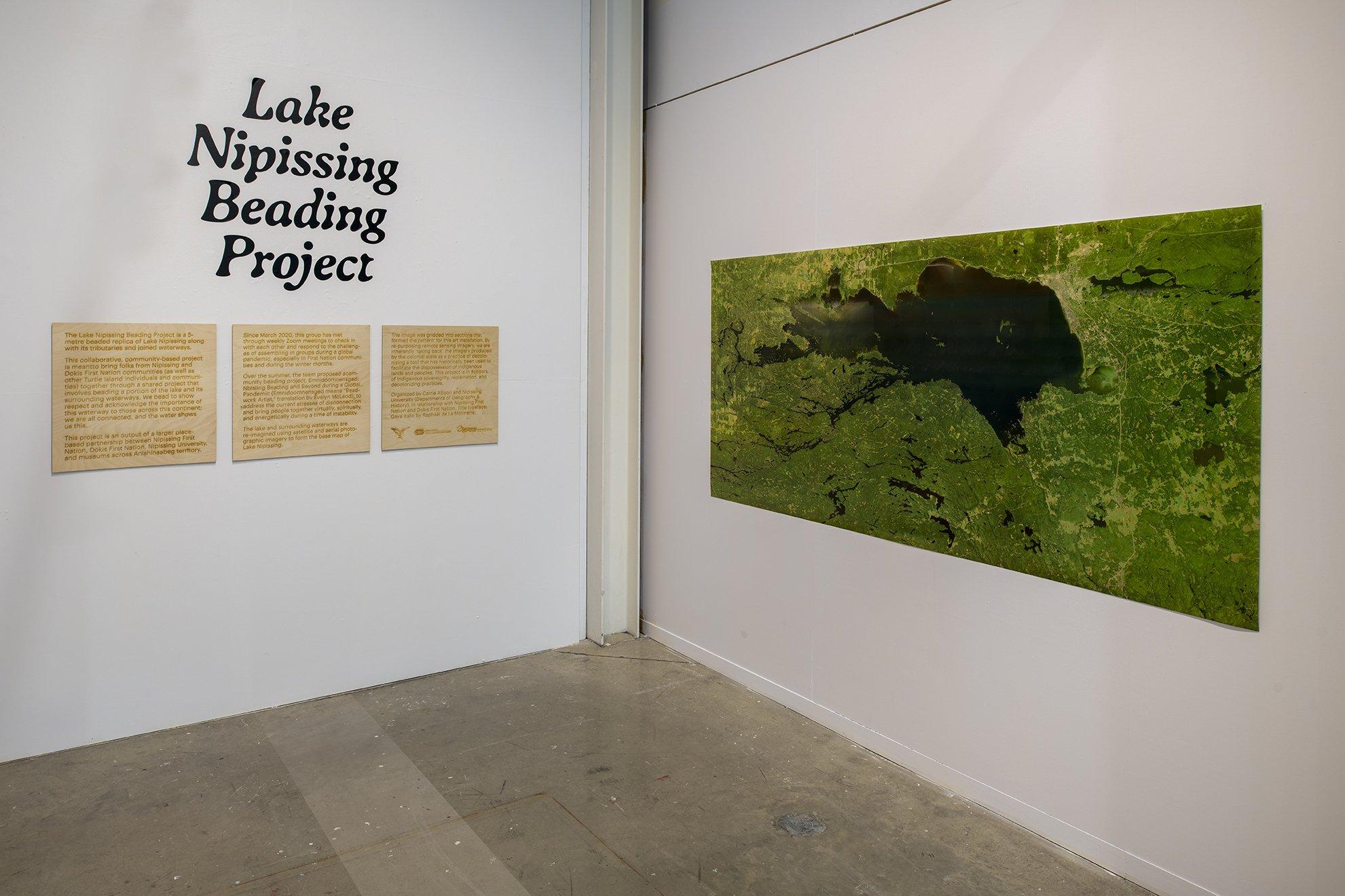 satellite map of Lake Nipissing with exhibition text printed on wood