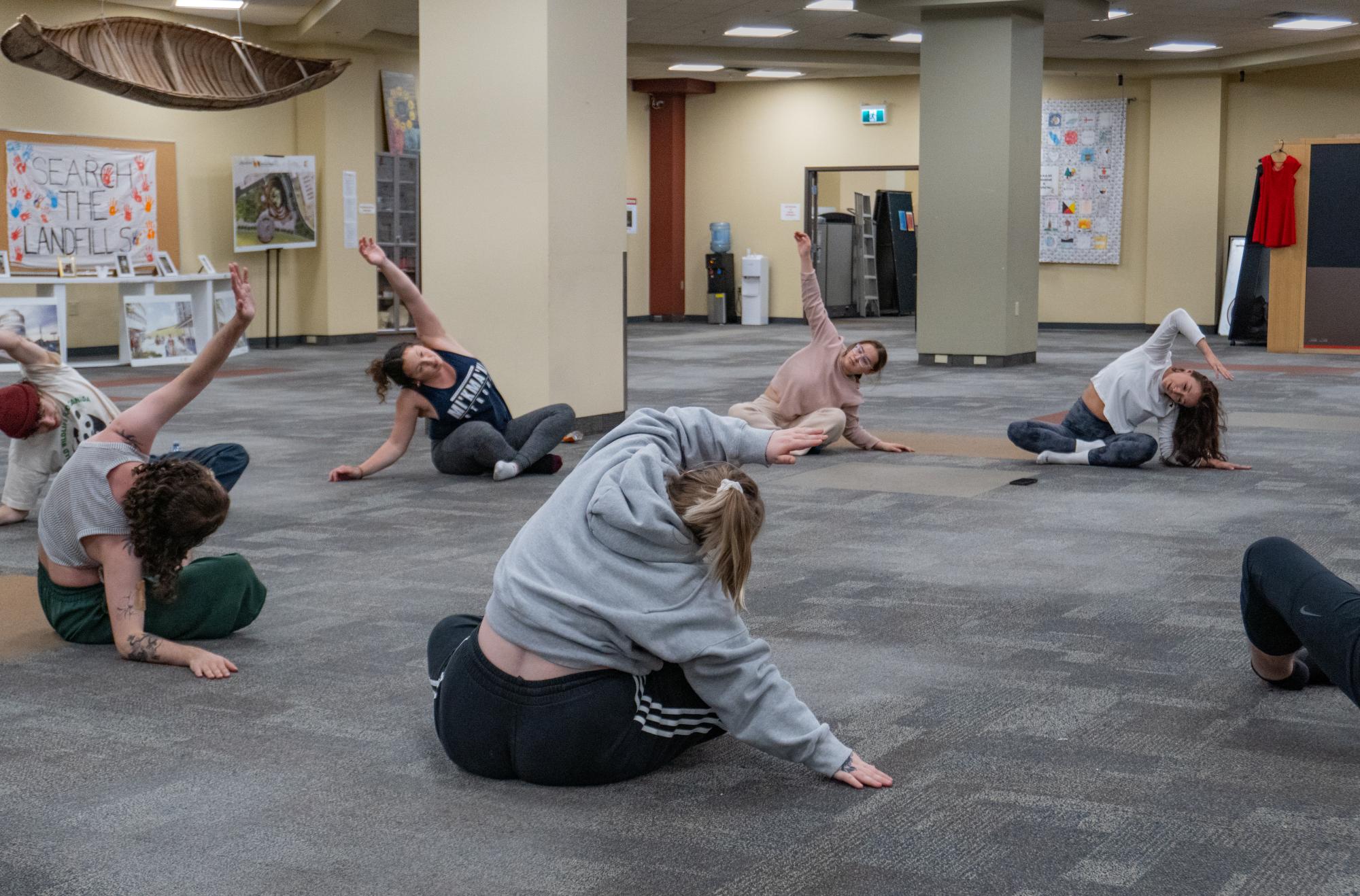participants siting in a circle stretching arms  