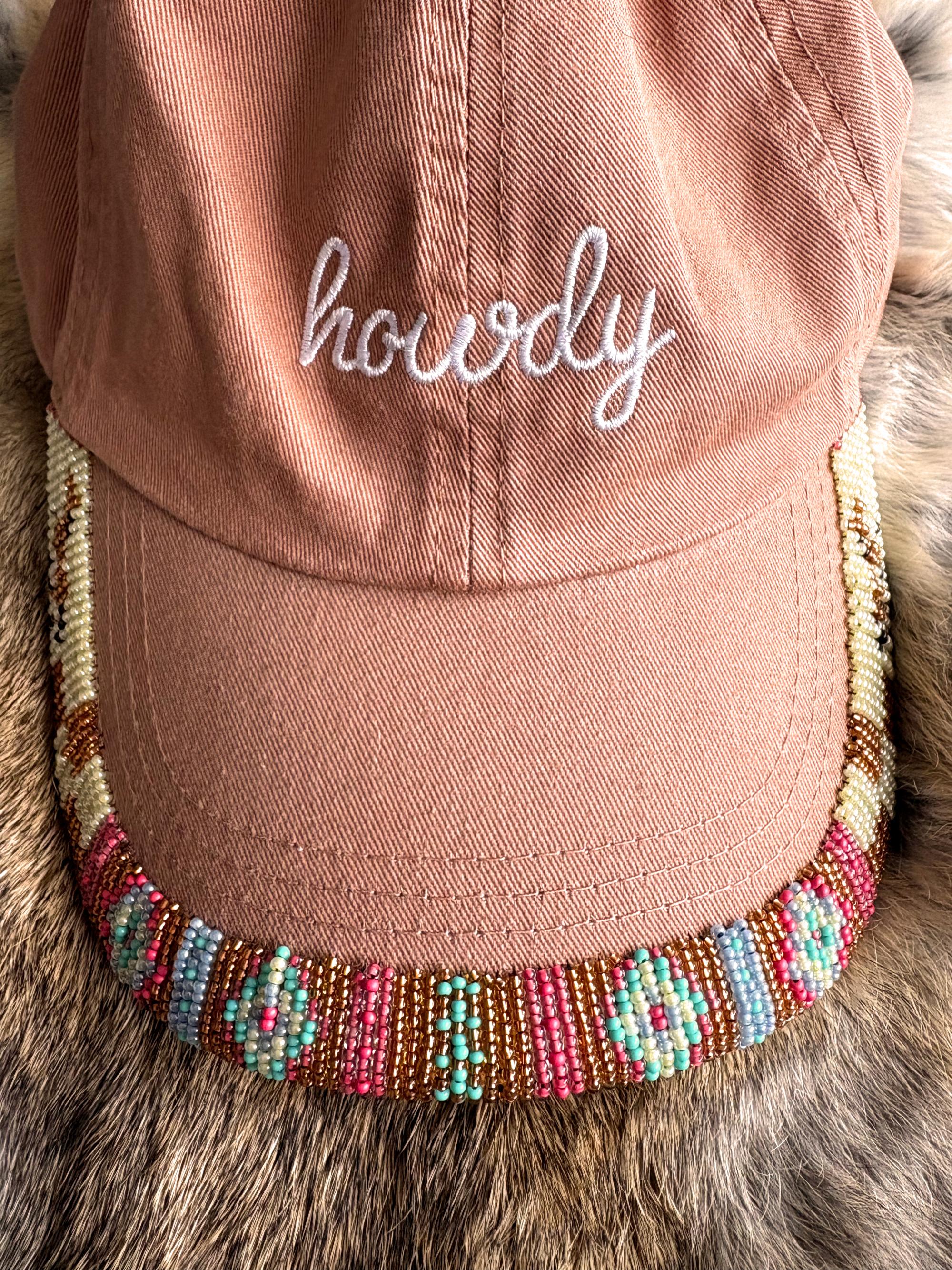 Beaded edge on a pink ball cap hat with the text on the cap saying "howdy" made by Cailin Gerrard