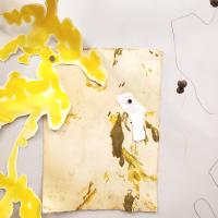 Yellow painted paper cut out like a shadow of leaves collaged over abstract drawings in brown and ochre