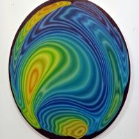 An abstract painting evoking waves, a weather chart or Op art. An optical glass lens used to paint an oval shape canvas.