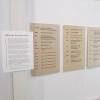 photograph of wooden boards mounted on white wall with black and red vinyl text listing the treaties in North America