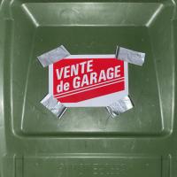 A garage sale sign that reads "Vente de Garage" is duct taped to a green trash bin lid. 