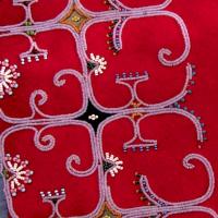 beadwork with unique design patterns on red felt fabric